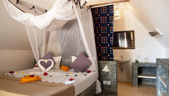 Nur Beach Hotel Jambiani bungalow bedroom with mosquito net